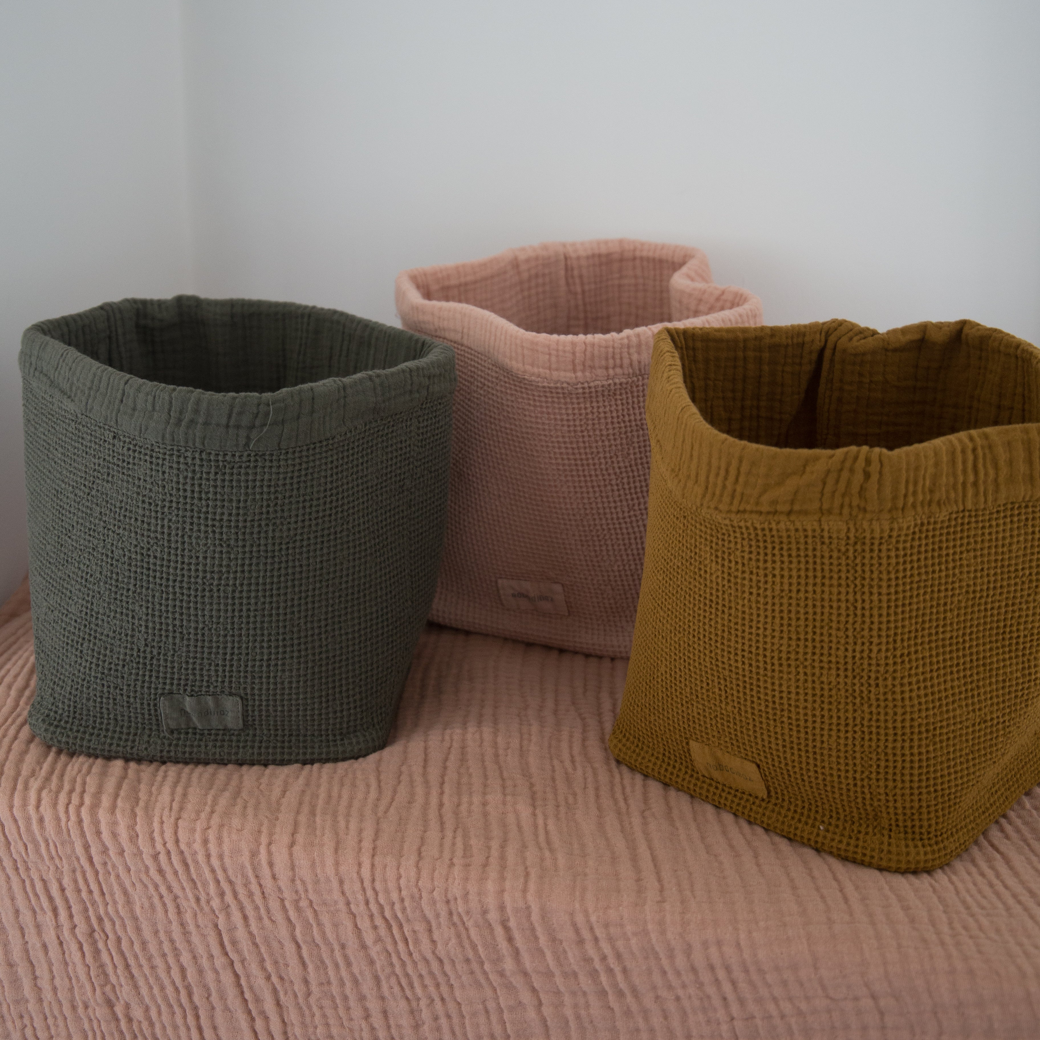 nobodinoz wabi sabi waffle baskets in three sizes displayed next to one another on a cotton pink throw 