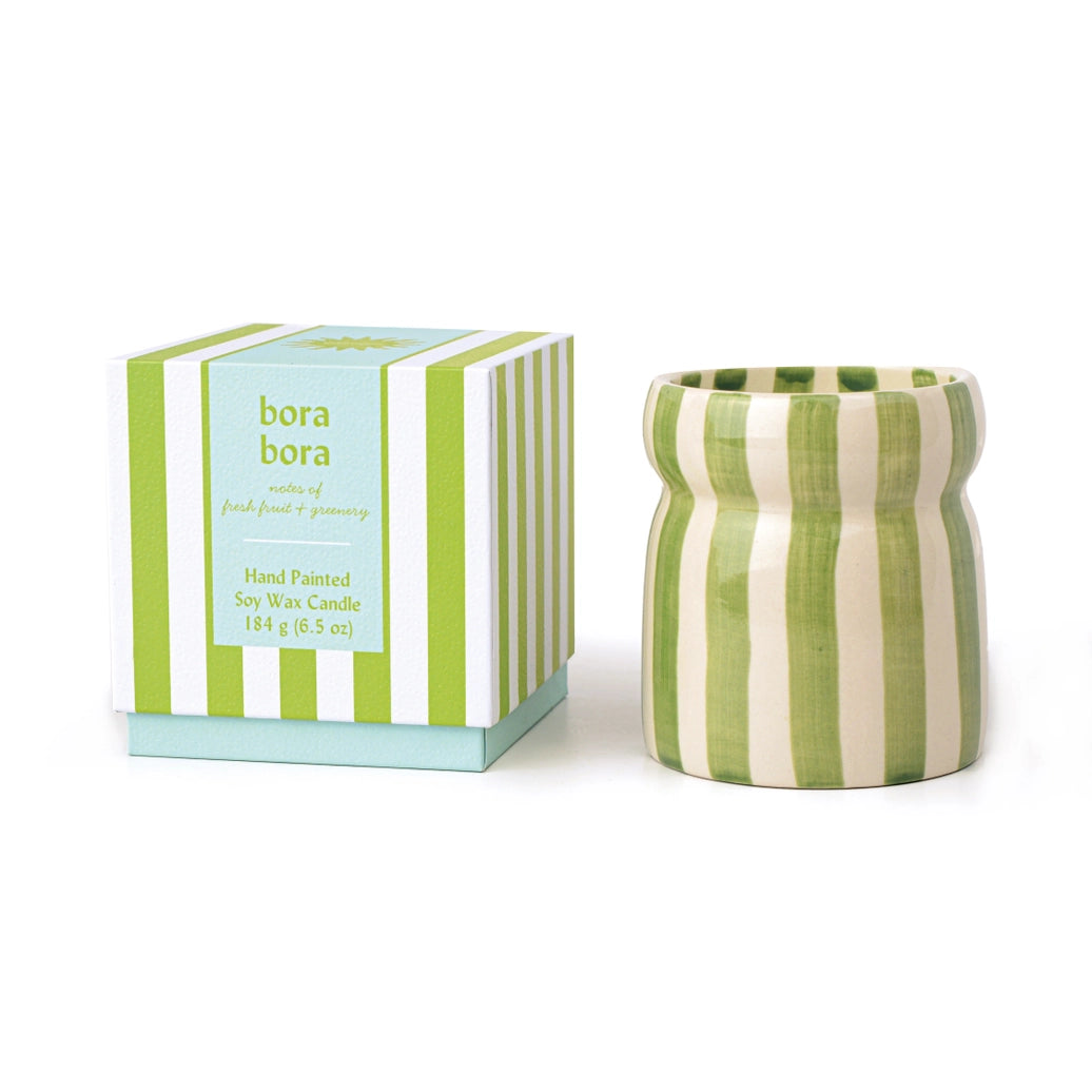 Green and white striped candle with matching box on a white background
