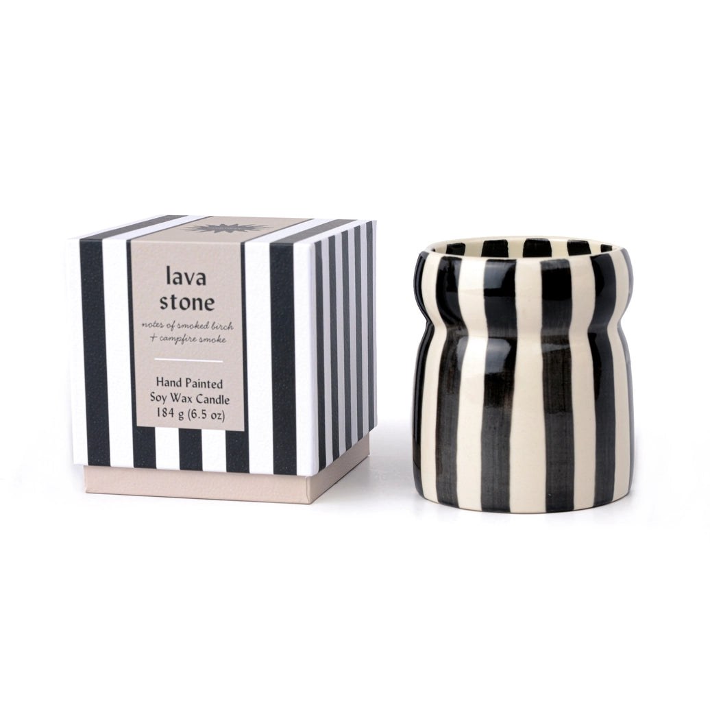 Black and white striped candle with matching packaging on a white background