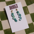 Green marbled earrings on a white card with 'KALEI' branding, against a green and beige checkered background.