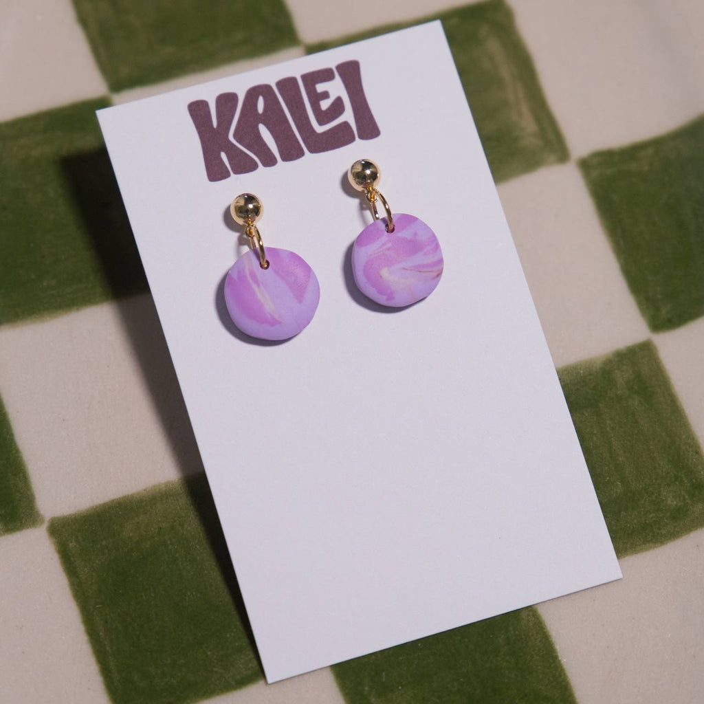 Purple marbled earrings on a 'KALEI' branded card against a checkered background