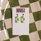 Green and white checkered earrings on a 'Kalei' branded card against a green and white checkered background.
