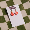 Pair of earrings on a KALEI branded card against a checkered background