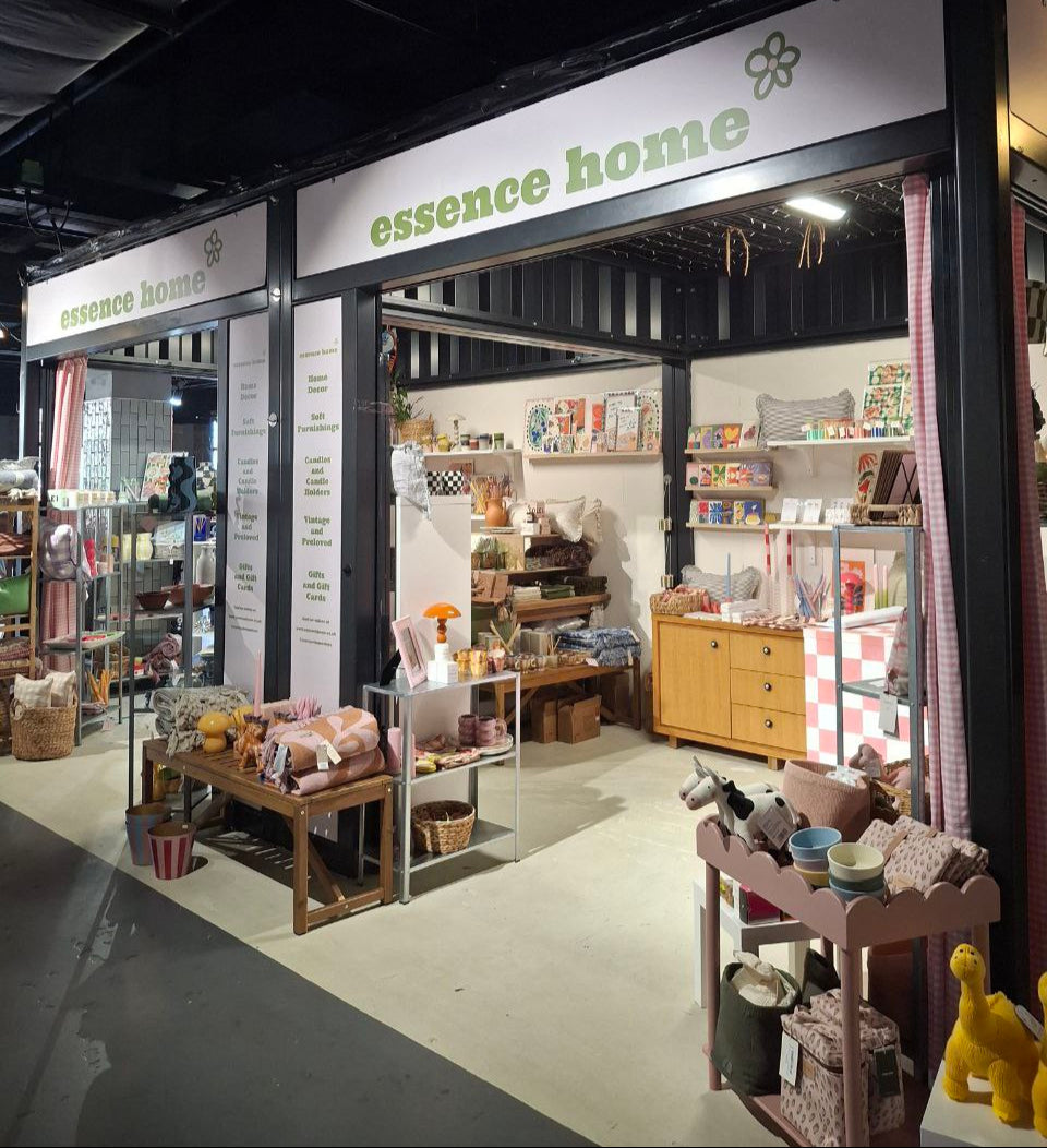 Storefront of 'essence home' with various products displayed inside.