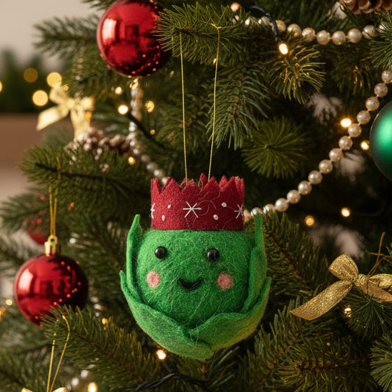 Felt brussel sprout ornament with a red crown on a white background
