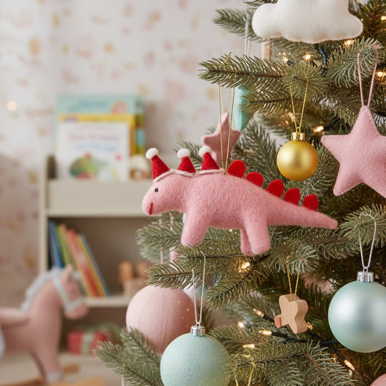 Pink dinosaur ornament with red hats and tail on a white background