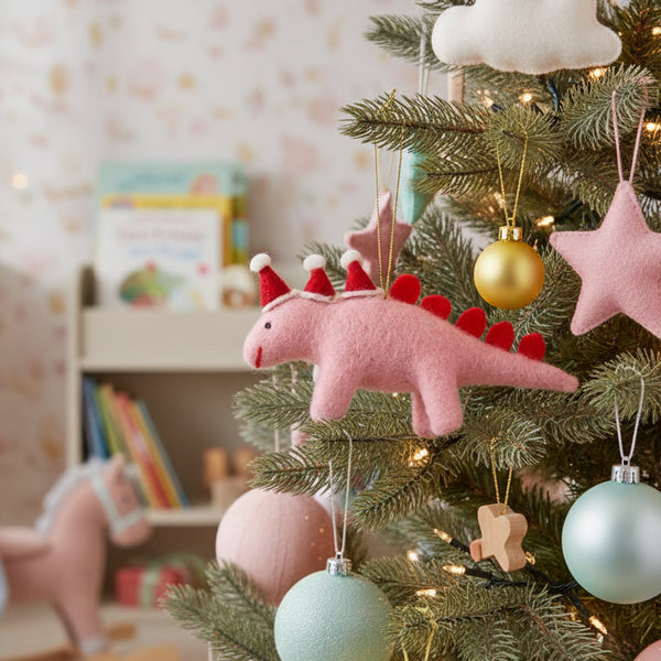 Pink dinosaur ornament with red hats and tail on a white background